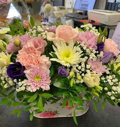 Country Garden - A lovely country style arrangement present in an attractive container in a mix of soft pinks, pastel purples and whites. Created and delivered by Moody Cows Florist in Carluke.