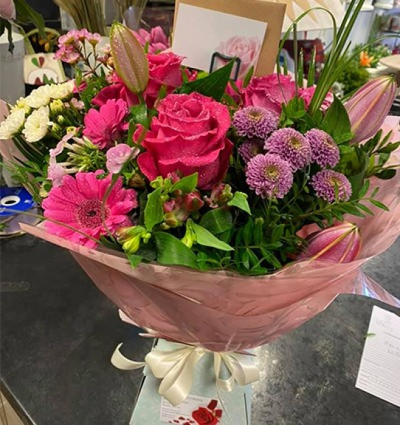 Pink Sensations - A stunning floral hand tied of roses, carnations, lilies and all in pretty shades. This is sure to brighten anyone's day. Created and delivered in Carluke by Moody Cows Florist.