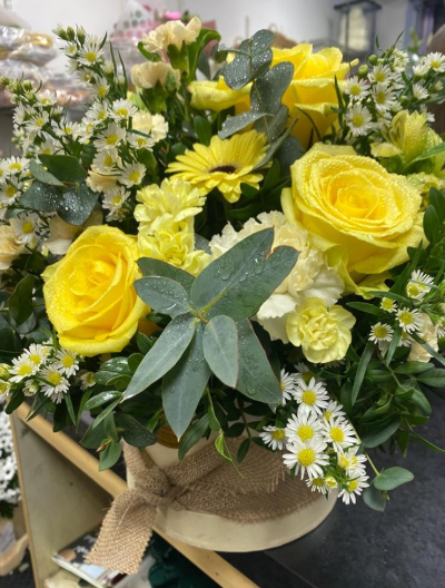 Little Ray of Sunshine - A cheerful arrangement in sunny yellow, cream and white tones with fresh greenery.